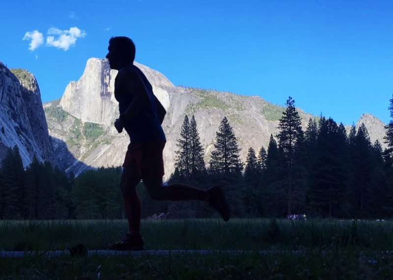 Running, silhouetted against the backdrop of Half Dome in Yosemite National Park.